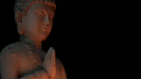Rotating sitting Buddha statue candle light tilt up against black background Stock Footage 65489483