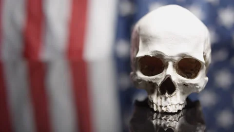 Rotating skull on American Flag background reflection - death in the USA Stock Footage 141531438