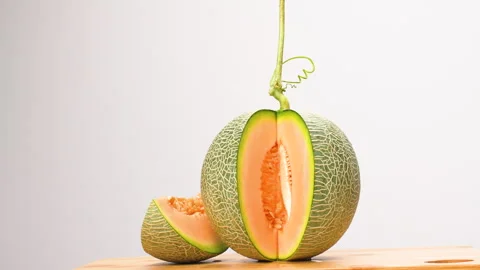 Rotating Sliced Green Netted Melon Orange Flesh On White Background 4K Stock Footage 323022727