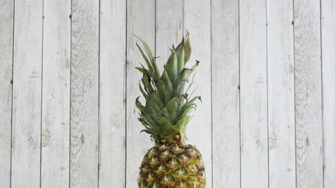 Rotating sliced pineapple on wooden theme Stock Footage 141668542