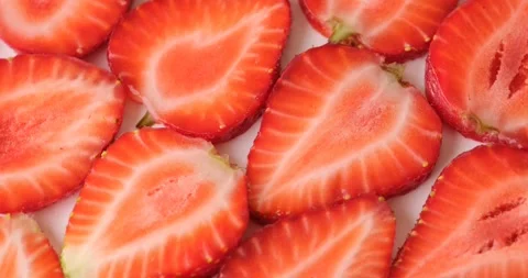 Rotating sliced strawberries form vivid natural composition Stock Footage 314108430