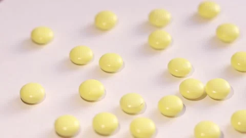 Rotating small yellow pills Stock Footage 146490071