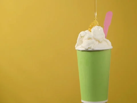 Rotating soft vanilla ice cream in green paper cup with plastic spoon Stock Footage 82878275