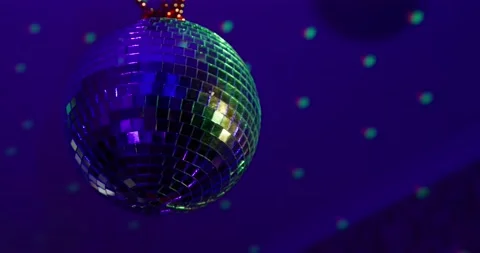 Rotating sparkling mirror disco ball weighs on the ceiling in the room changes Stock Footage 166421338
