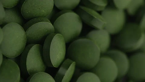 Rotating Spirulina, chlorella supplement pills close up Stock Footage 133784530