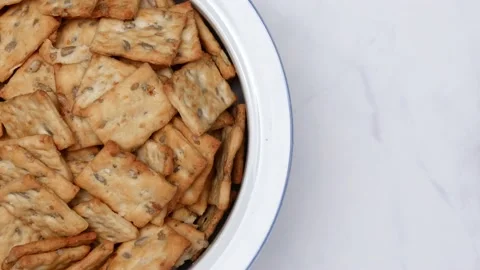 Rotating Square Cracker Biscuit With Vegetable Flavored And Crumbs In White Plat Vídeos de archivo 164315949