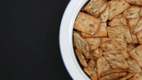 Rotating Square Cracker Biscuit With Vegetable Flavored And Crumbs In White Plat Vídeos de archivo 164315966