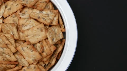 Rotating Square Cracker Biscuit With Vegetable Flavored And Crumbs In White Plat Vídeos de archivo 164315975