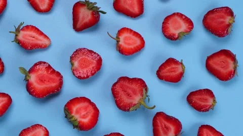 Rotating strawberry cut in half on a blue background, strawberry texture or Stock Footage 197667510