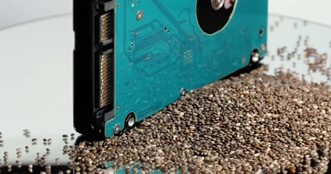 On a rotating table is a hard drive and a pile of chia seeds. 4K footage Stock Footage 154244305