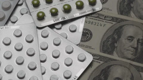 Rotating tablets in pharmaceutical or blister packs with dollar bills. Stock Footage 120230832