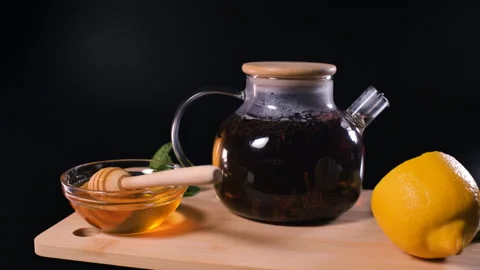 Rotating teapot with tea beside lemon and honey Stock Footage 345704341