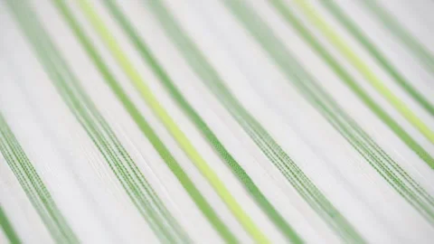 Rotating texture of white cotton material with a thin green stripe. close up. Stock Footage 243190345