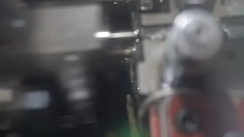 Rotating tooling spins inside a dark screw making machine while a steel wire Vídeo Stock 346737822