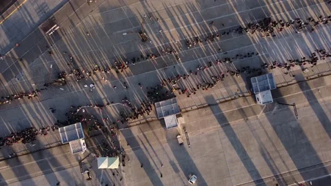 Rotating top down aerial view of long queue during sunset Stock Footage 202005427