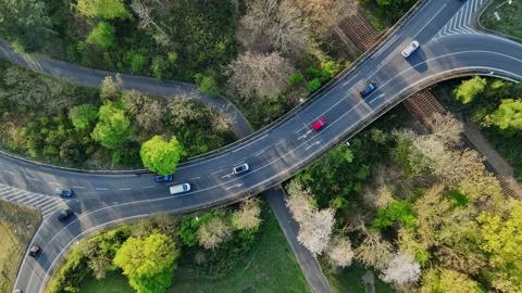 Rotating top-down drone shot over road with car traffic near industrial area Stock Footage 309233613