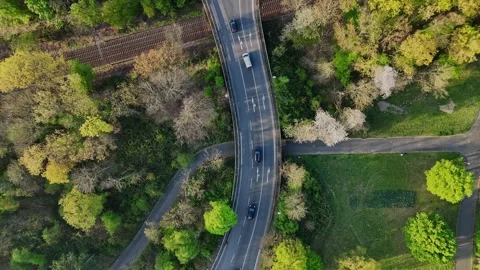 Rotating top-down drone shot over road with car traffic near industrial area Stock Footage 309233780