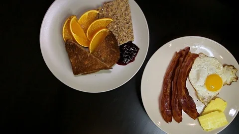 A rotating top down view of two plates full of traditional breakfast foods on a Stock Footage 124397341