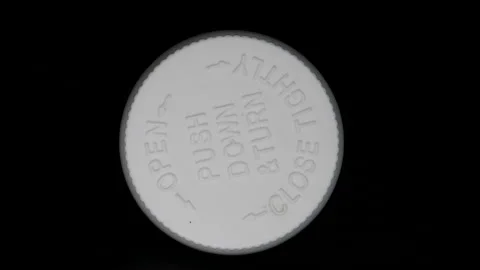 Rotating Top View Of The Cap Of A Bottle With Pills Labeled Push Down And Turn O Stock Footage 143097105