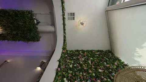 Rotating upward view of a flower wall and chandelier greenery Stock Footage 345565272