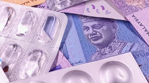 Rotating used empty pill blisters over brand new Malaysian ringgit banknotes. Stock Footage 297153480