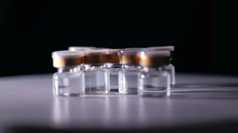 Rotating Vaccine Vials Symbolizing Global Biotechnology Race and Innovation Stock Footage 339766586