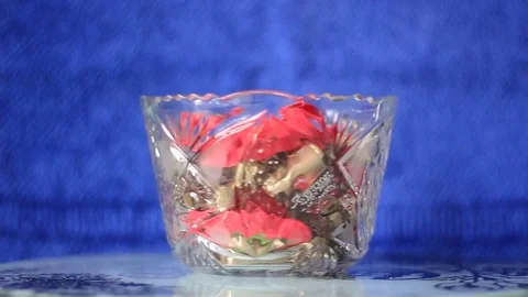 Rotating vase with candies on blue background Stock Footage 72814569