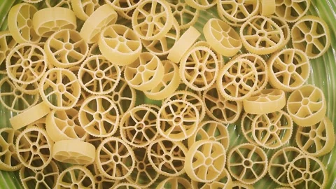 Rotating video close-up of Ruote pasta with wheel-shaped patterns, showcasing Stock Footage 342188655