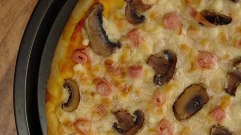 Rotating video of a mushroom pizza with ham and lots of melted cheese Stock Footage 282563029
