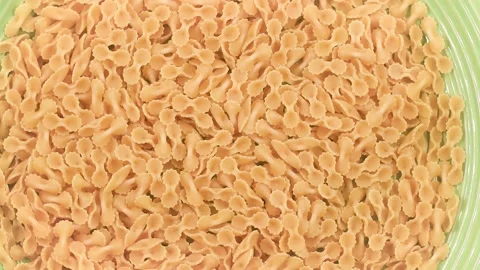 Rotating video of uncooked Farfalline pasta with delicate bow tie shapes, Stock Footage 342188835