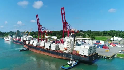 Rotating view of cargo vessel docked at pier, cranes, shipping containers Video stock 155070757