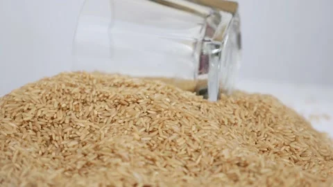 Rotating view of glass placed over heap of brown rice Stock-Footage 147690358