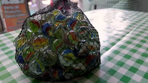 Rotating view of marble balls stacked in net packet. Stock Footage 321207742