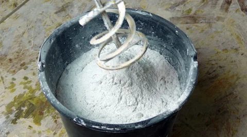 Rotating Whisk Mixer Immersed in Plaster Mix in Bucket Stock Footage 44228361