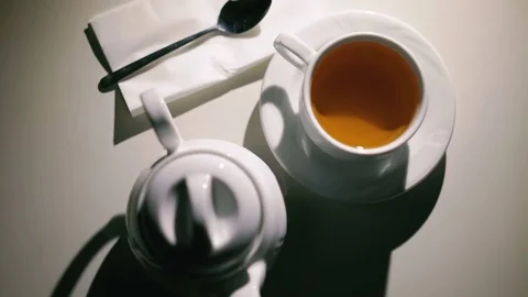 Rotating white background with cup of tea, spoon and teapot in 4K 動画素材 72256440