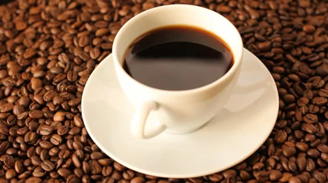 Rotating white cup of coffee with coffee beans and ground coffee around Stock Footage 35209726