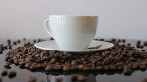 Rotating white cup of Steamy coffee with coffee beans  Stock Footage 35215896