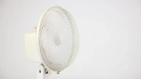 Rotating white fan ventilator on left side on white background, summer cooling Video stock 157594572