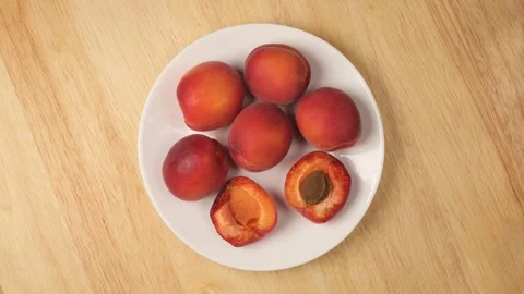 Rotating white plate full of fresh apricots Stock Footage 344603960