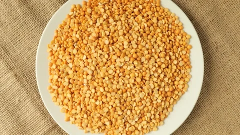 Rotating white plate of yellow split peas Stock Footage 339367081