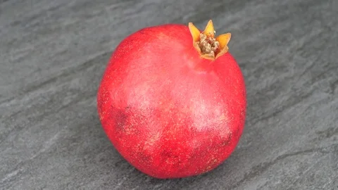 Rotating whole pomegranate fruit on stone background, top view. Stock Footage 83671759