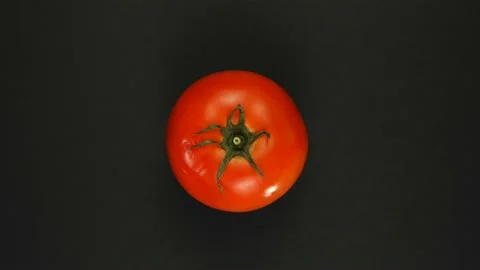 Rotating whole tomato on a black background isolate. Fresh juices, vegetable Stock Footage 166915200