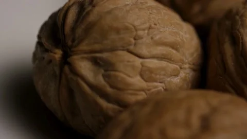 Rotating whole walnuts in brown shells on white background Stock Footage 327911457