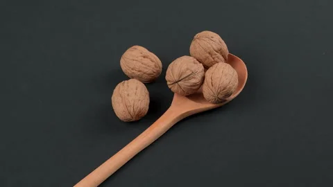 Rotating Whole Walnuts In Shell On Wooden Spoon Black Background 스톡 동영상 332527701