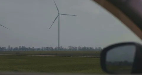 Rotating Wind Generators In The Field, View From The Car Window. Wind Turbine Stock Footage 123712321