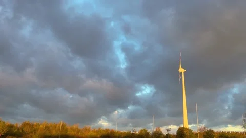 Rotating wind mill with big grey clouds in the sky Stock Footage 220594483