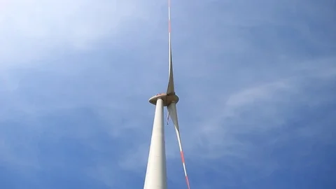 Rotating wind turbine propeller blades in the blue sky - view from the ground Stock Footage 75538505