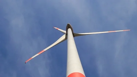 Rotating wind turbine propeller blades in the blue sky - view from the ground Stock Footage 75545984