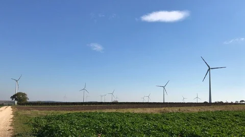 Rotating wind turbine towers on fields produce energy Stock Footage 96153586