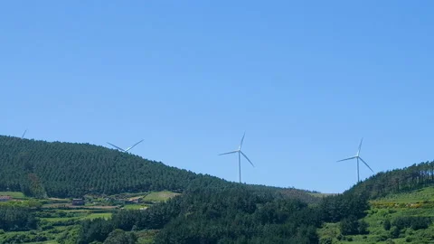 Rotating wind turbines on green hill, clean energy farm, eco technology Stock Footage 136767494